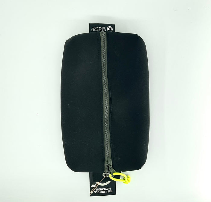 A black case with a zipper, made from upcycled materials, with a yellow tag and a label that includes the text 'The Upcycle Movement'.