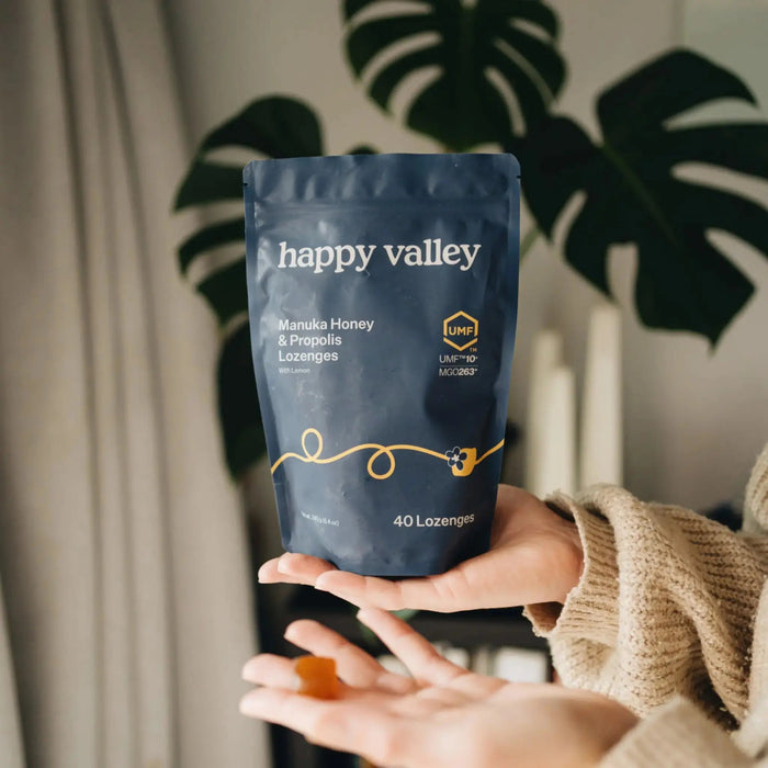 Happy Valley Honey UMF 10+ Manuka Honey and Propolis Lemon Lozenges in a clear container, showing the lozenges inside.