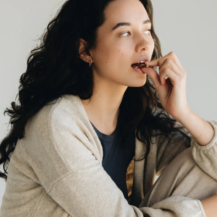Happy Valley Honey UMF 10+ Manuka Honey and Propolis Lozenges being enjoyed by a woman, showcasing natural throat relief.