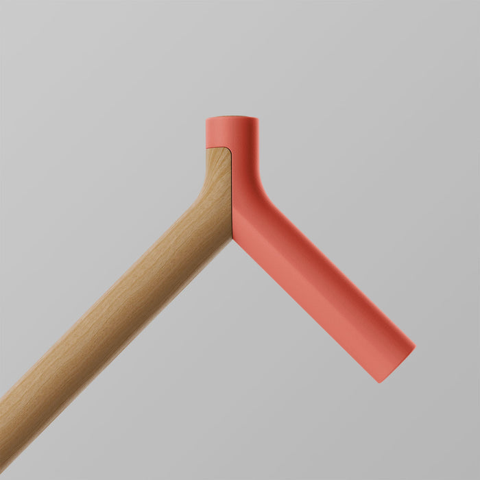 Ooak Uno walking stick with a coral-colored handle and oak wood shaft, featuring a triangle design for stylish support.