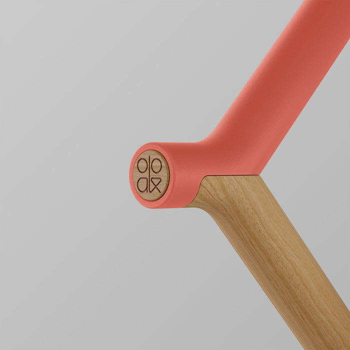 Ooak Uno walking stick with coral-colored handle and oak wood shaft, featuring the Ooak logo.