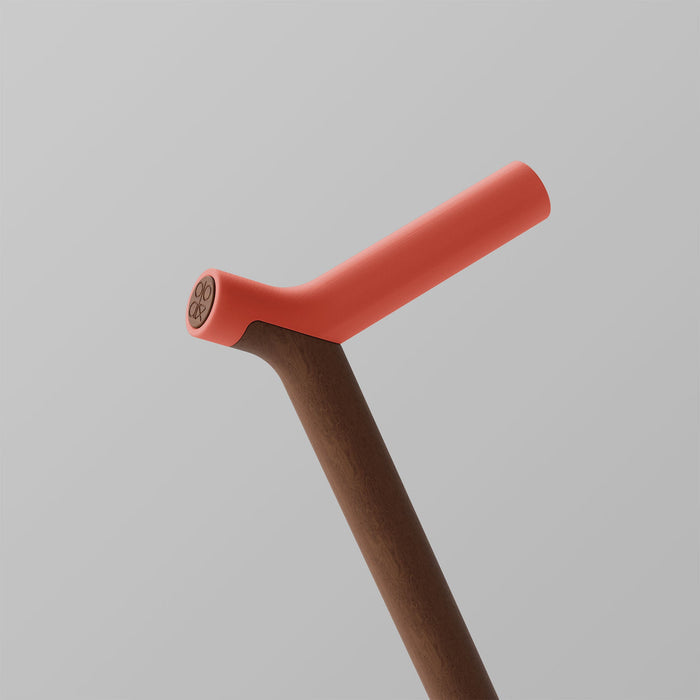 OOAK Uno walking stick featuring coral-colored handle and walnut shaft with ergonomic design and natural wood finish.