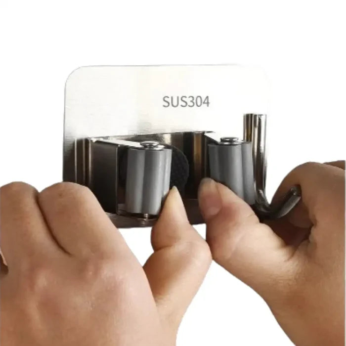Stainless steel wall-mount mop and broom holder with hooks for organizing cleaning tools.
