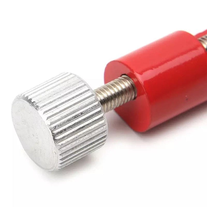 Red watch link remover tool from That Watch Shop, used for adjusting watch band links, with precise removal tips.