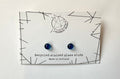 Pair of blue earrings on a WildBird Studio branded card with geometric design