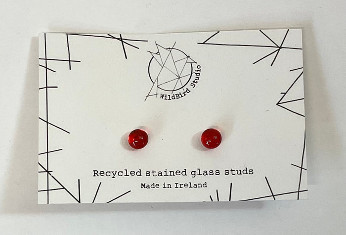 Red glass earrings on a card with 'wildBird studio' branding and text about recycled stained glass.