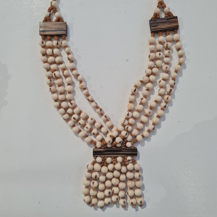 white beaded necklace made from acai seeds