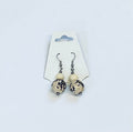 Pair of earrings with white and black amazon seed beads on a white card against a white background