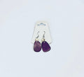 Purple earrings on a white card against a light gray background